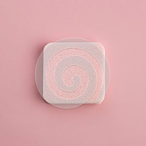 The Cosmetic sponge on a pink background. Top view
