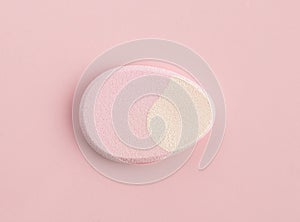 The Cosmetic sponge in the shape of an egg on a pink background. Top view