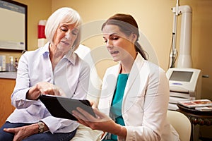 Cosmetic Surgeon Discussing Procedure With Client In Office