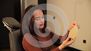 Cosmetic surgery. A silicone breast implant is smooth and rough in the hands of a young girl.