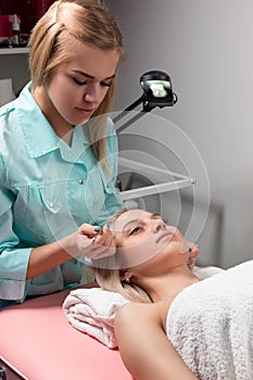 Cosmetician in a beauty salon behind work