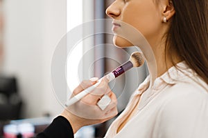 Cosmetician with brush and woman, cosmetics store