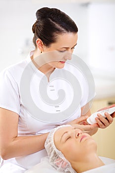 Cosmetician with cosmetic before procedure