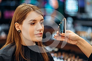 Cosmetician and female client in makeup shop