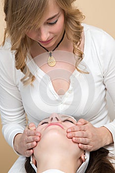 Cosmetician giving customer face massage photo