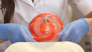 Cosmetician removing mask from client face at beauty salon. Top view