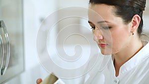 Cosmetician taking a cosmetic from cabinet and