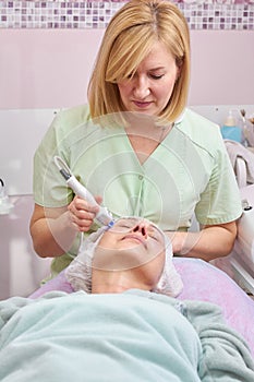 Cosmetician working with adult woman.