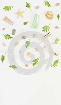 Cosmetics background. Cosmetics SPA makeup tubes, bottles, sea pebbles and shells on white background. Flat lay, top