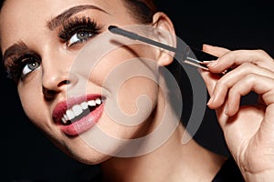 Cosmetics. Beautiful Woman With Perfect Makeup Applying Mascara