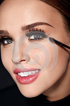 Cosmetics. Beautiful Woman With Perfect Makeup Applying Mascara