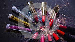 Cosmetics and beauty industry, a set of lipsticks on a background of loose powder and eye shadow,