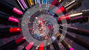 Cosmetics and beauty industry, a set of lipsticks on a background of loose powder and eye shadow,