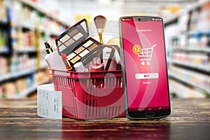 Cosmetics and beauty products buying online concept. Shopping basket with makeup products and mobile phone on shelf of cosmaetics