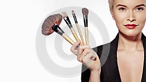 Cosmetics and Beauty Treatment. Beautiful Girl with Make-up Brushes. Makeover. Makeup Artist Applying Visage photo