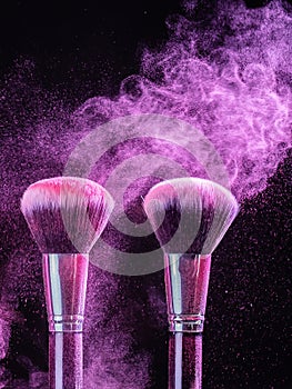 Cosmetics brush and explosion colorful makeup powder background - beauty make-up product and mineral cosmetic concept