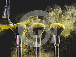 Cosmetics brush and explosion colorful makeup powder background - beauty make-up product and mineral cosmetic concept