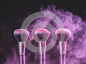 Cosmetics brush and explosion colorful makeup powder background - beauty make-up product and mineral cosmetic concept