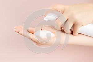 Cosmetics foam pump container, facewash dispenser in a woman`s hand