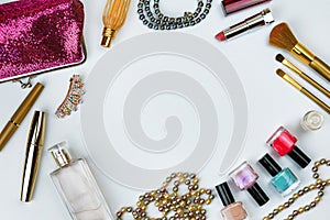 Cosmetics, jewelry, perfumes and a beautiful pink cosmetic bag on a white background, top view