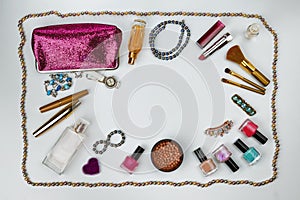 Cosmetics, jewelry, perfumes and a beautiful pink cosmetic bag on a white background, top view