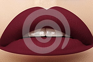 Cosmetics, makeup. Bright lipstick on lips. Closeup of beautiful female mouth with dark red lip makeup. Part of face