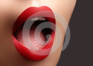 Cosmetics, makeup. Bright lipstick on lips. Closeup of beautiful female mouth with red lip makeup. Clean skin model