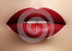 Cosmetics, makeup. Bright lipstick on lips. Closeup of beautiful female mouth with red lip makeup. Part of face