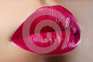 Cosmetics, makeup. Bright lipstick on lips. Closeup of beautiful female mouth with red and pink lip makeup. Part of face