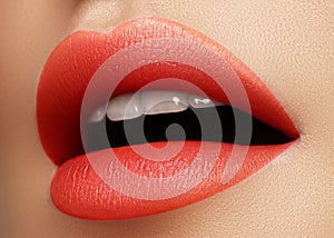 Cosmetics, makeup. Bright lipstick on lips. Closeup of beautiful female mouth with red and pink lip makeup. Part of face