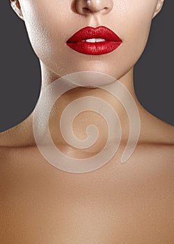 Cosmetics, makeup. Bright lipstick on lips. Closeup of beautiful female mouth with red and red lip makeup. Part of face