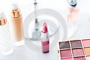 Cosmetics, makeup products on dressing vanity table, lipstick, foundation base, nailpolish and eyeshadows for luxury beauty and