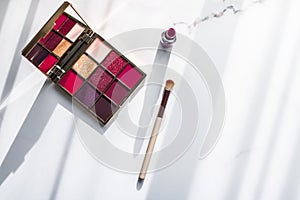 Cosmetics, makeup products set on marble vanity table, lipstick, eyeshadows and make-up brush for luxury beauty and fashion brand