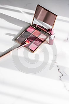 Cosmetics, makeup products set on marble vanity table, lipstick, eyeshadows and make-up brush for luxury beauty and fashion brand