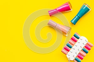 Cosmetics for manicure with nail polish and palette for spring design in nail bar yellow background top view copyspace