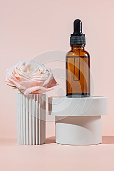 Cosmetics packaging. Amber glass dropper bottle with face serum on white concrete podiums. Blank packaging. Natural