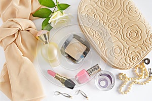 Cosmetics, perfumes, jewelry made of pearls and handbag on a white background.