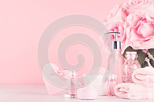 Cosmetics products for bath, spa - essential oil, bath salt, cream, liquid soap, towel, heart and pink roses in delicate pink.