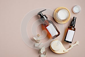 Cosmetics SPA branding mockup. Dark amber glass pump bottle dispenser and spray, facial cleaning brush, natural organic body cream