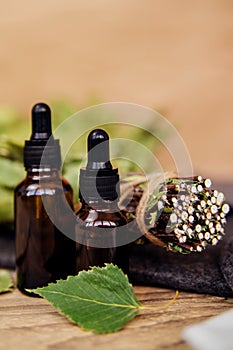 Cosmetics for spa treatments and baths on a wooden table with a birch broom. Essential oils