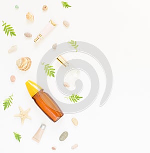 Cosmetics summer background. Cosmetics SPA makeup tubes, bottles, sea pebbles and shells on white background. Flat lay