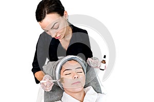 Cosmetologist administering chemical peel treatment on patient in a beauty spa, for skin rejuvenation, complexion and acne beauty photo