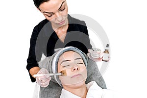 Cosmetologist administering chemical peel treatment on patient in a beauty spa, for skin rejuvenation, complexion and acne beauty