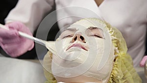 Cosmetologist applying facial mask to problem skin. young woman having skin procedures cleaning