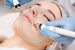 cosmetologist conducts microcurrent facial therapy for a young woman using a device in a beauty salon. Hardware