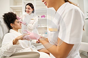 Cosmetologist consulting client during beauty injections in salon