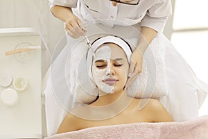 Cosmetologist do face mask for woman client