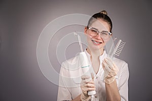 The cosmetologist doctor holds the darsonval device with different nozzles.