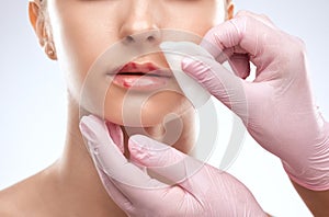 Cosmetologist does injections for lips augmentation and anti wrinkle in the nasolabial folds of a beautiful woman. Women\'s
