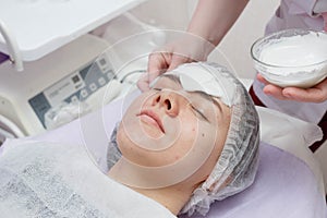 A cosmetologist does an ultrasonic cleaning of the skin of the face